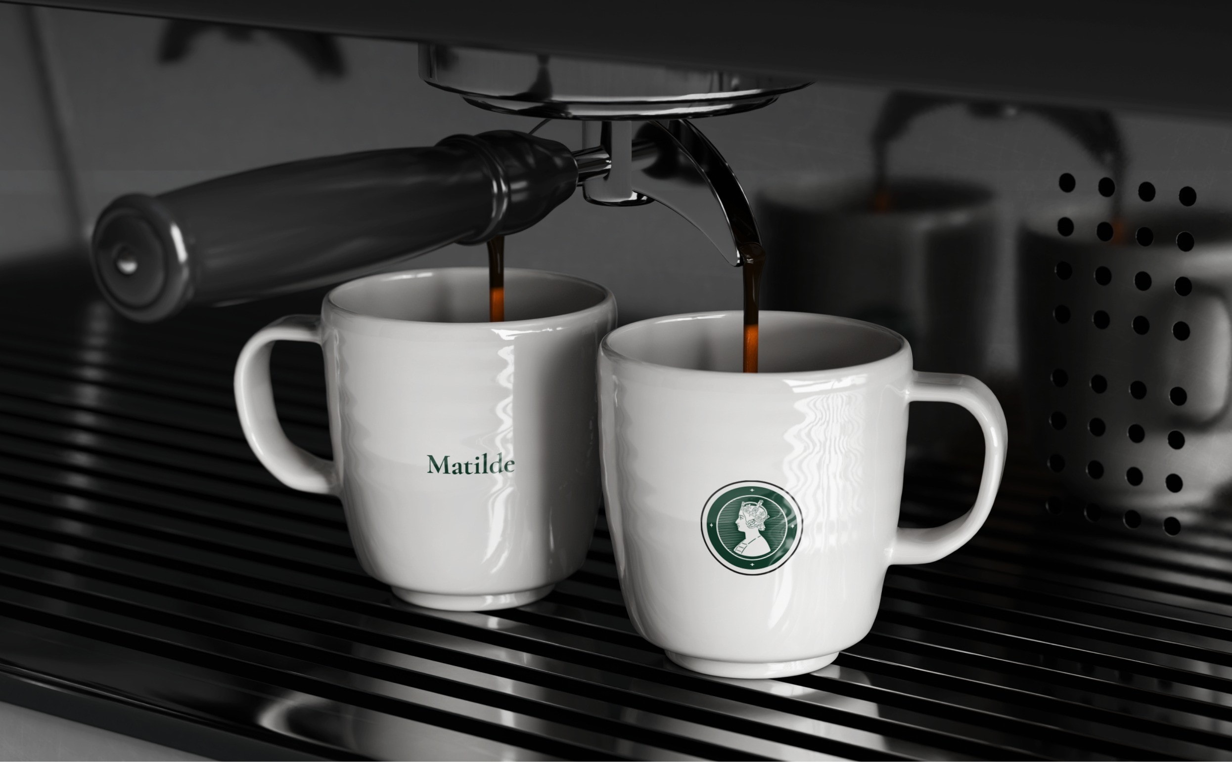 Two branded cups filling under an espresso machine