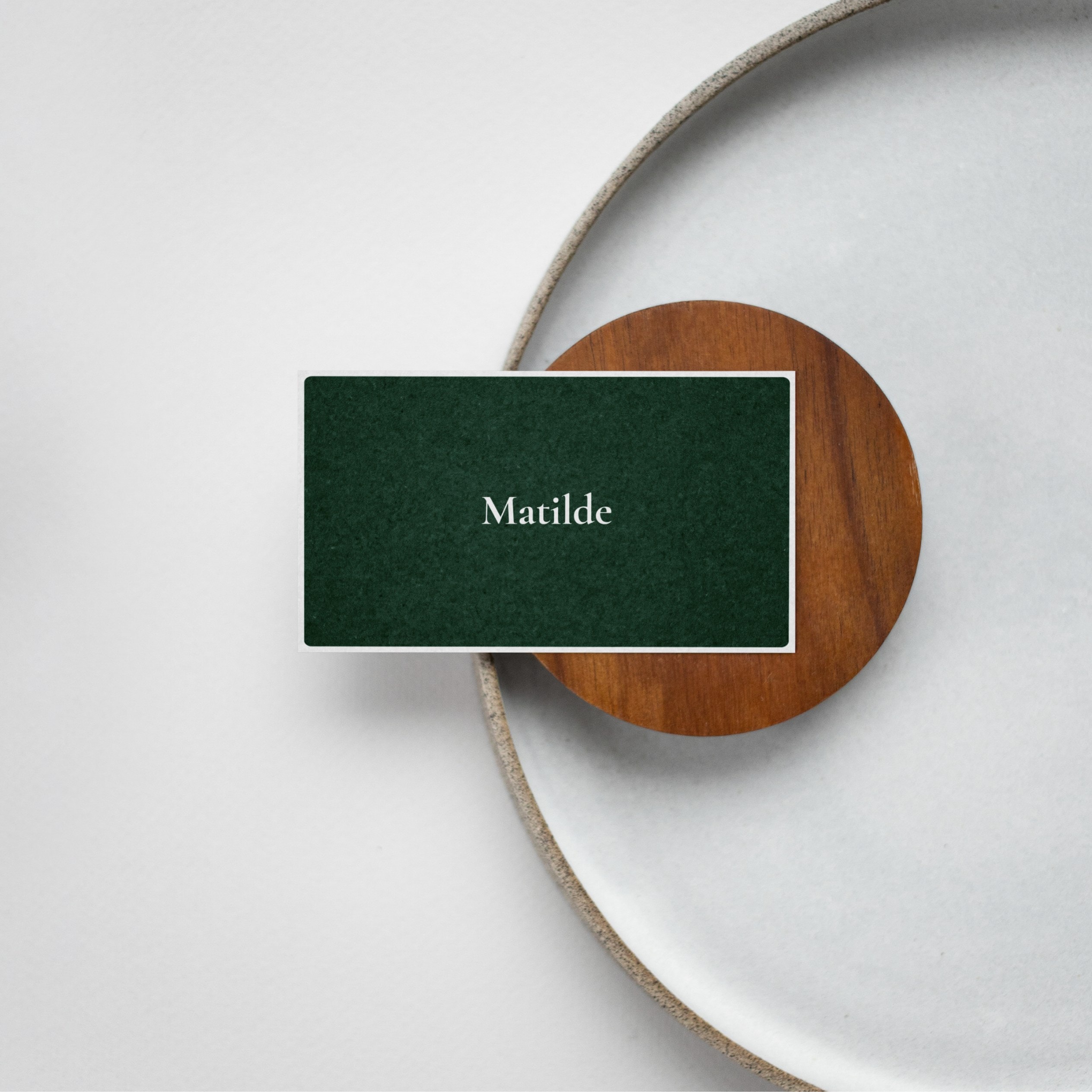 A green card on a wooden coaster