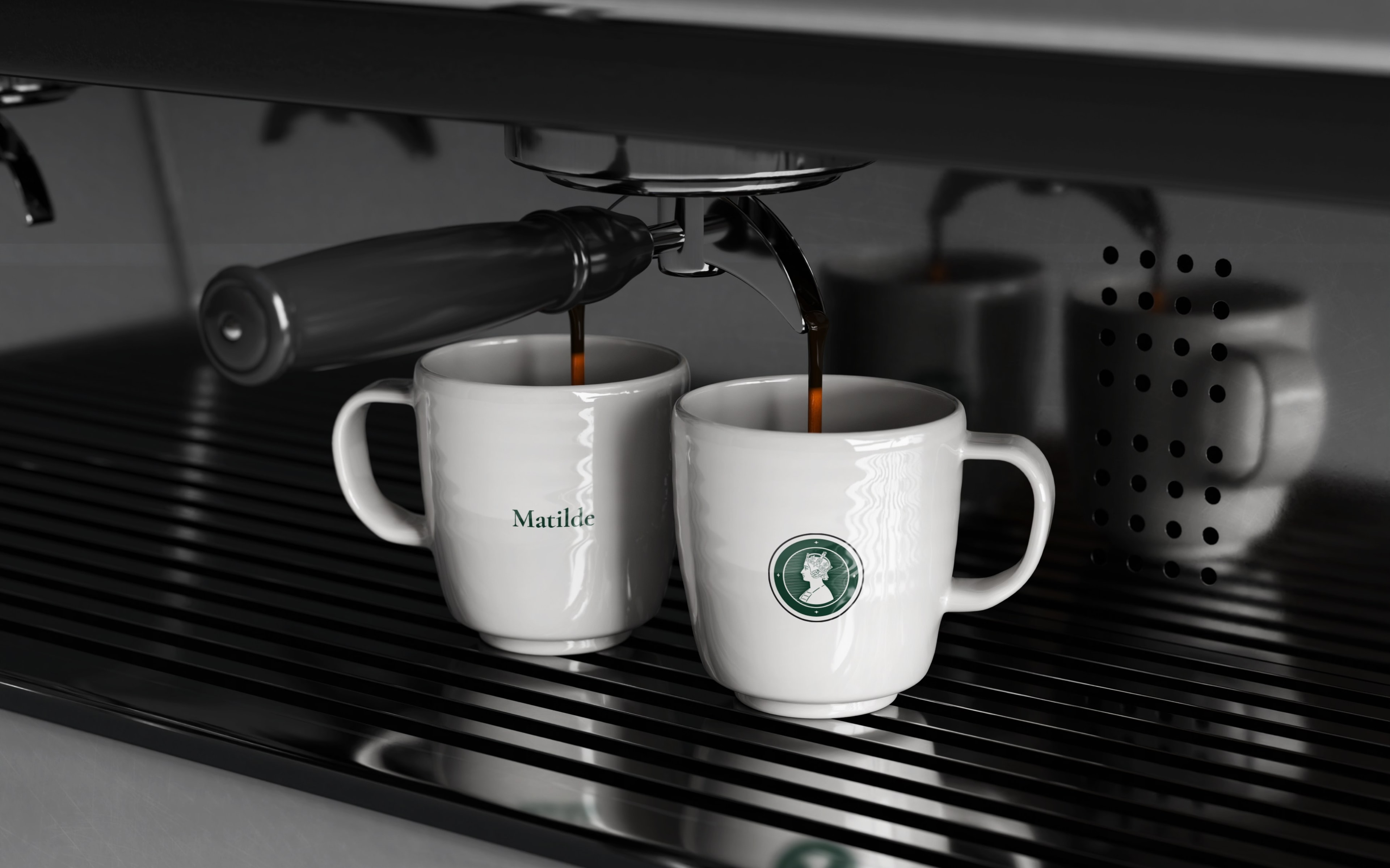Two branded cups under the espresso machine