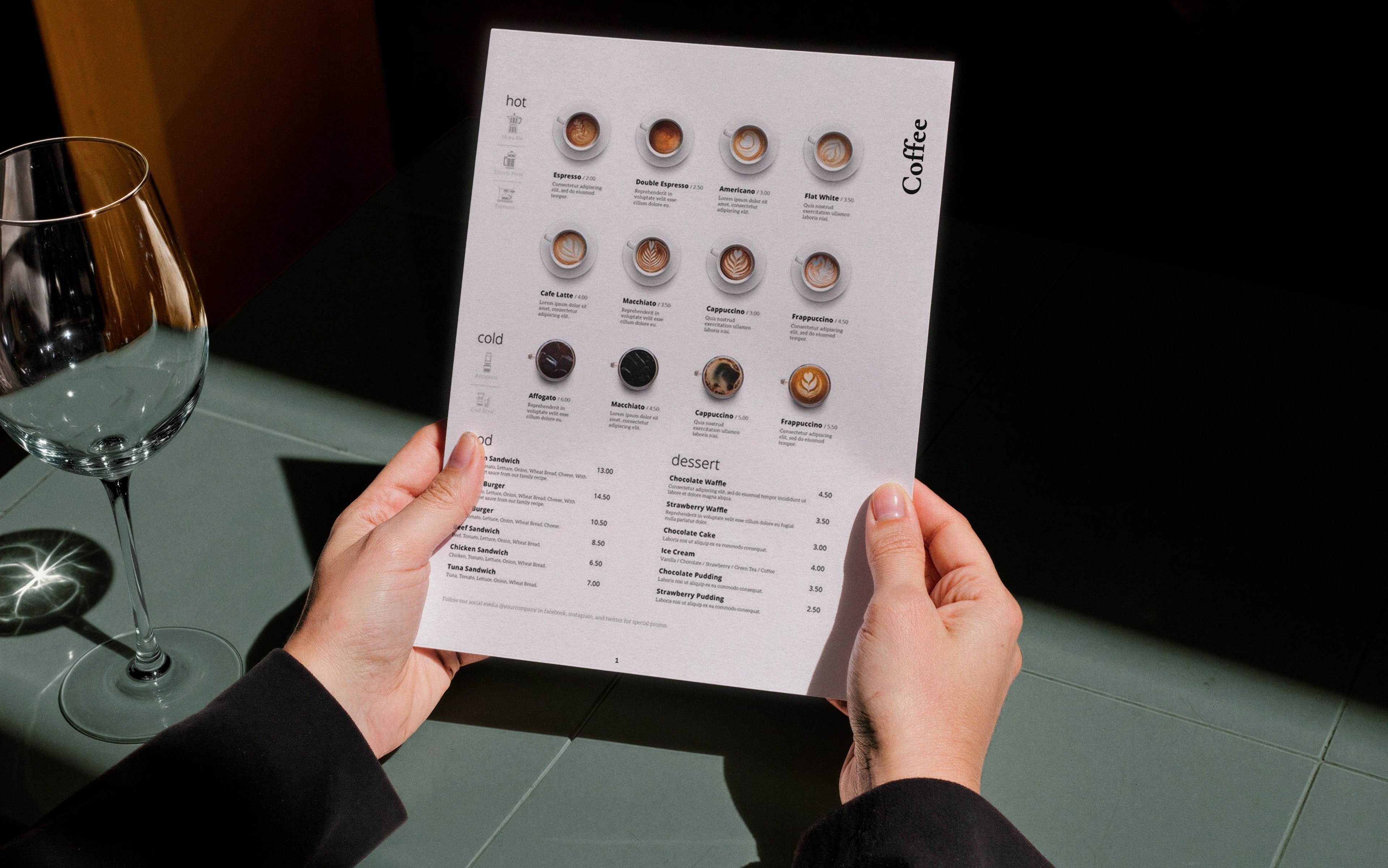 Hands holding the paper menu at a table