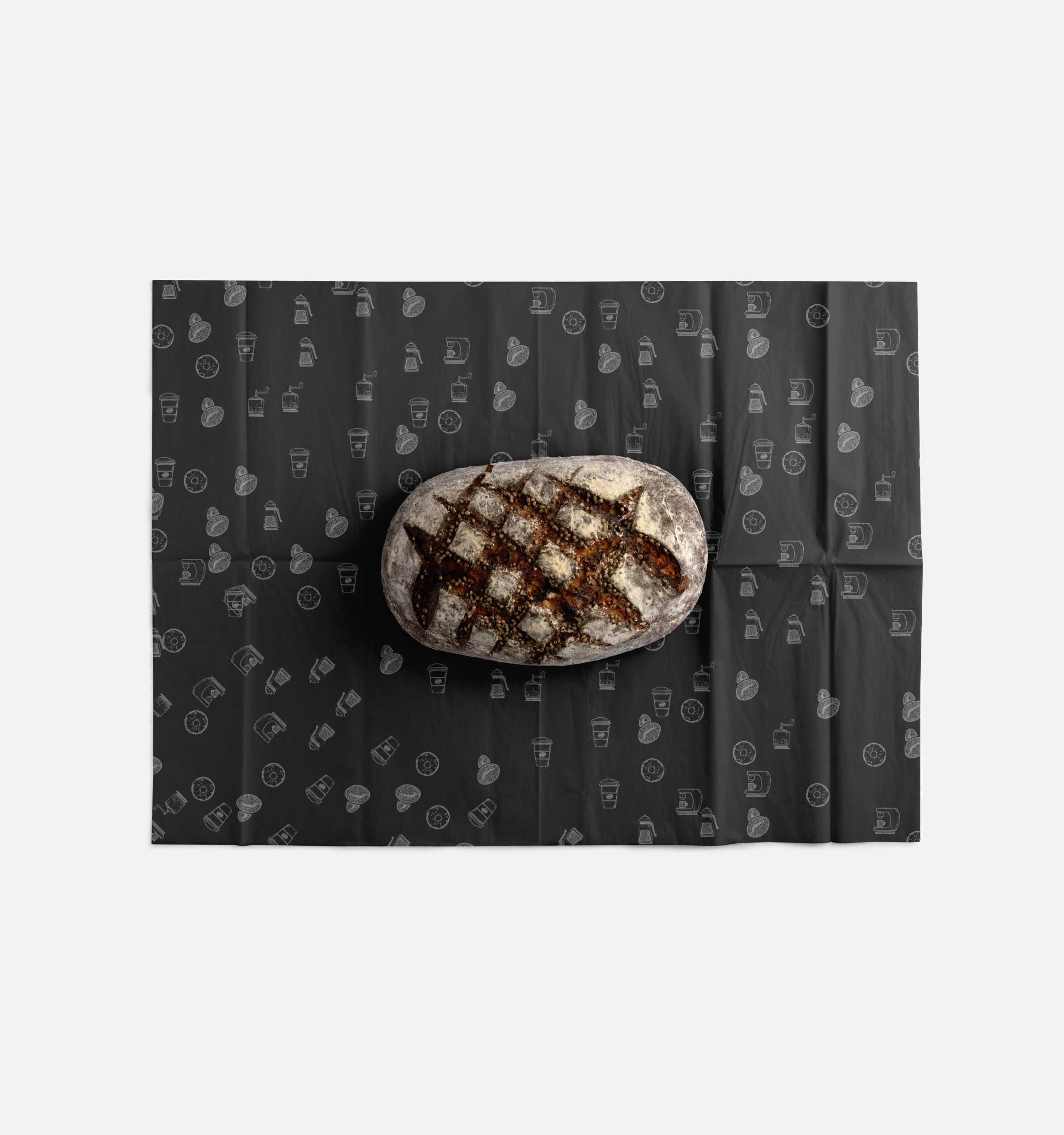 A sourdough loaf resting on patterned paper